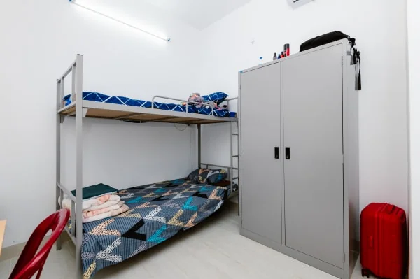 Spacious student hostel room with air conditioning and study desks